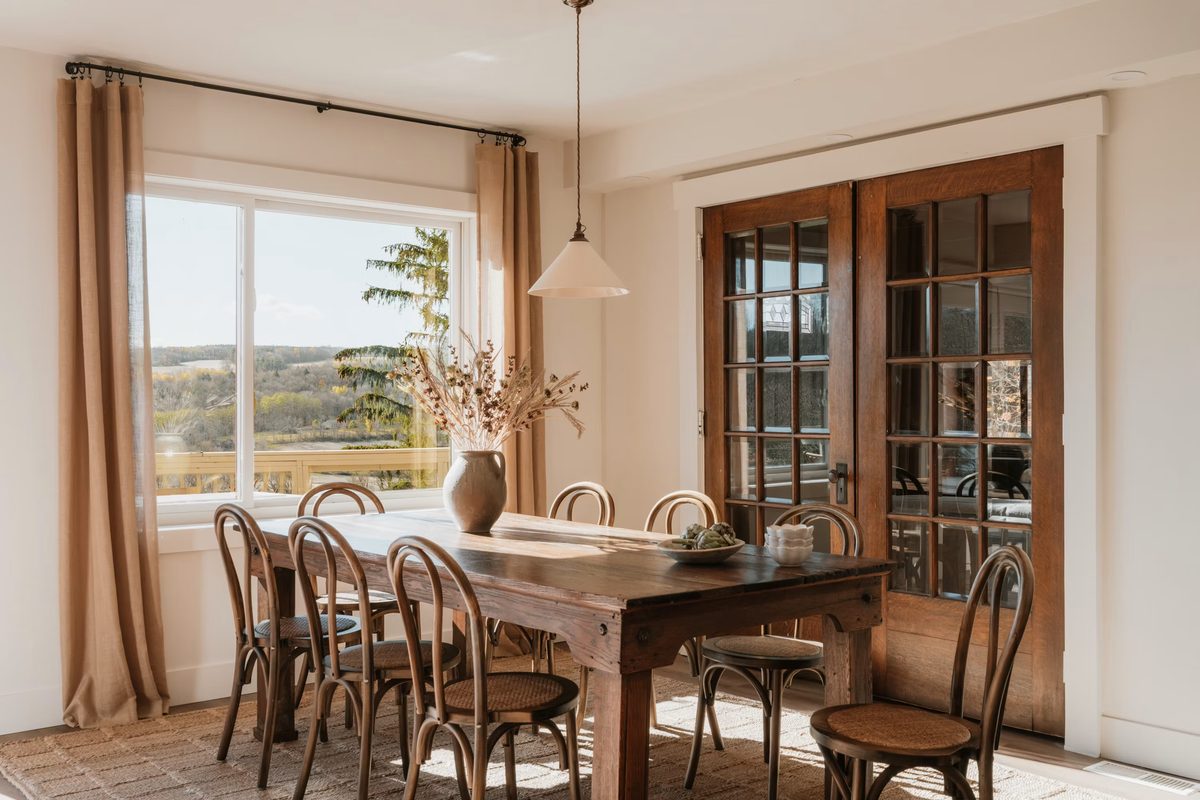 Grande table de ferme en bois massif dans une salle à manger lumineuse